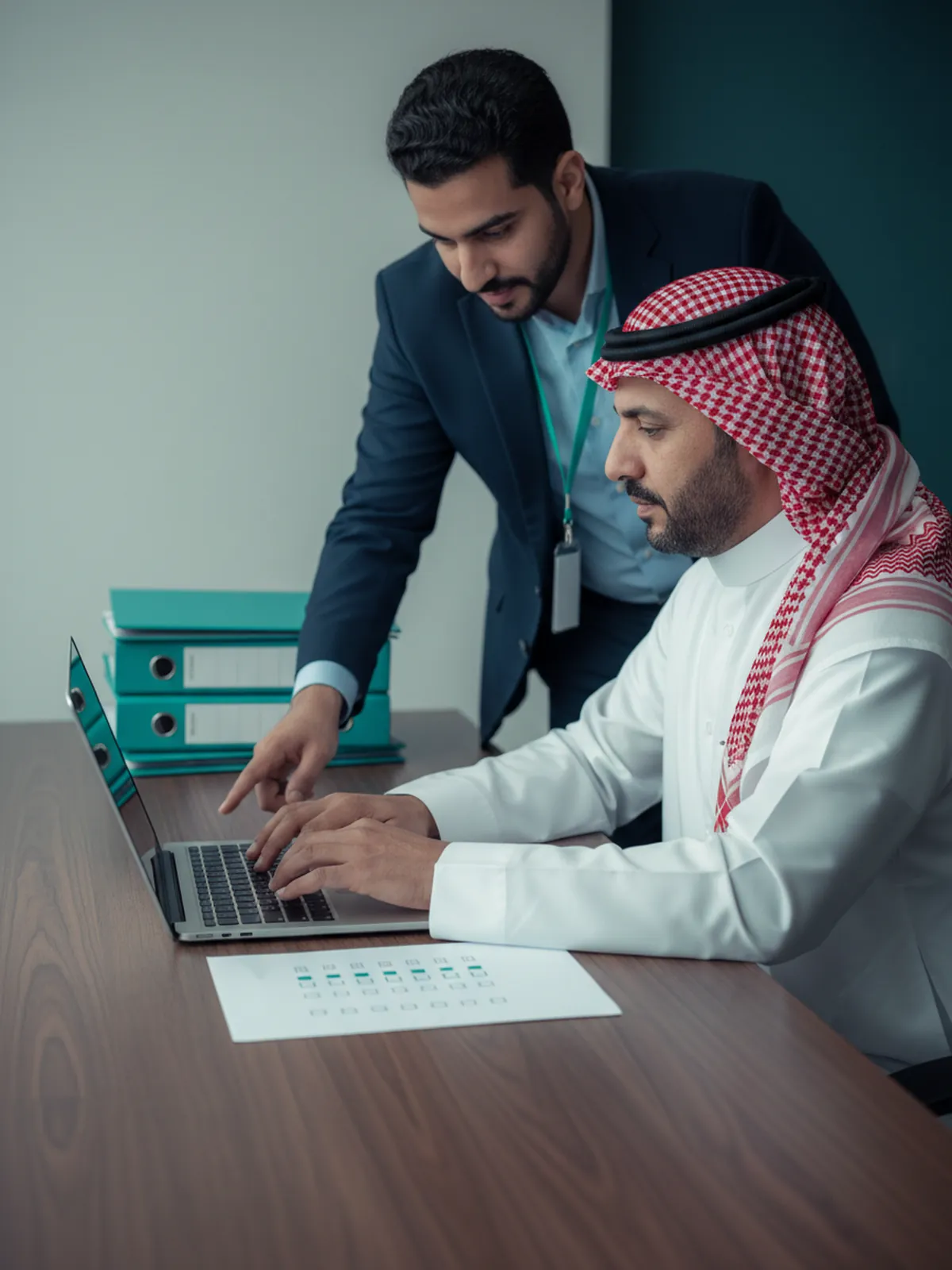 مدير شركة مقاولات يقدّم الطلب من حساب منشأته ومستشار من إضاءات بجانبه يتابع قائمة التحقق